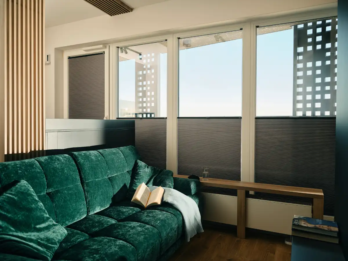 Gemütliches Wohnzimmer mit grünem Samtsofa und modernem Fensterdesign