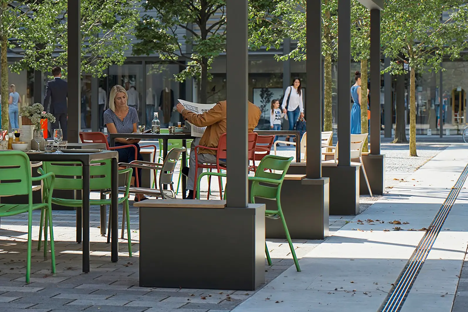 Sonnenschirmständer an einer Strasse mit mehreren Tischgruppen
