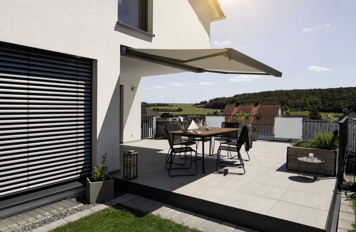 Moderne Terrasse mit Sonnenschutz und Aussicht auf die Landschaft