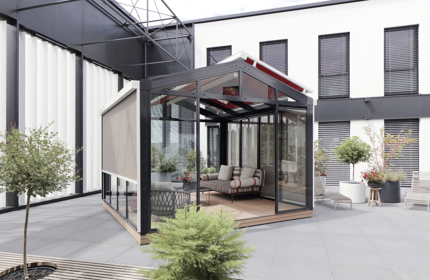 Moderner Wintergarten auf einer Terrasse mit bequemen Möbeln und Pflanzen