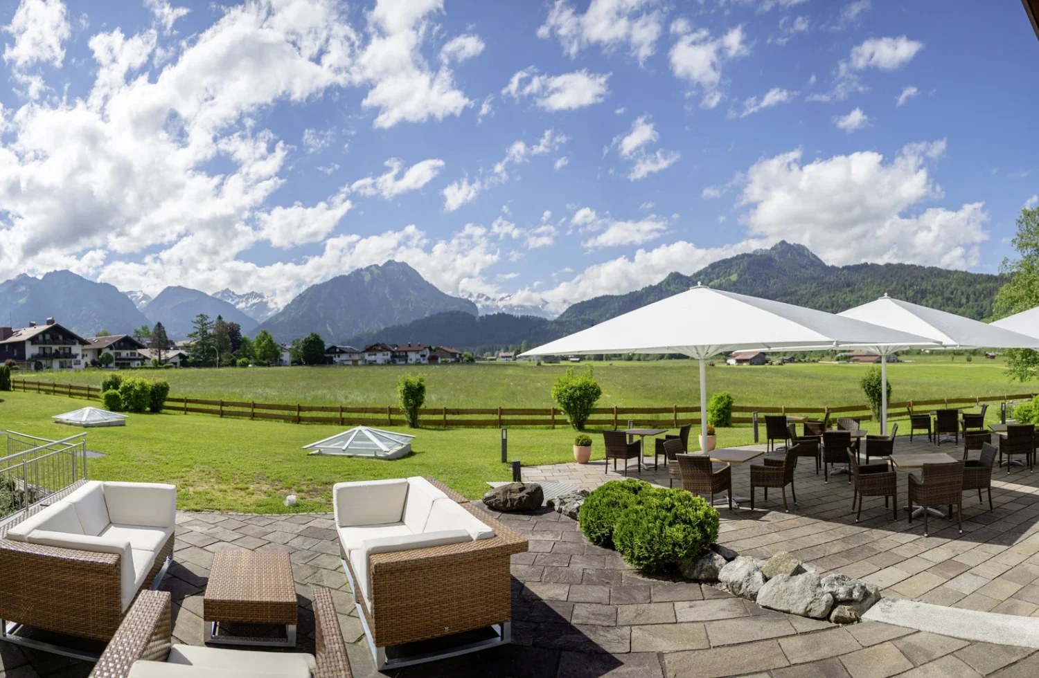 Panorama von einer Terrasse mit Blick auf die Alpen und sonnigem Wetter
