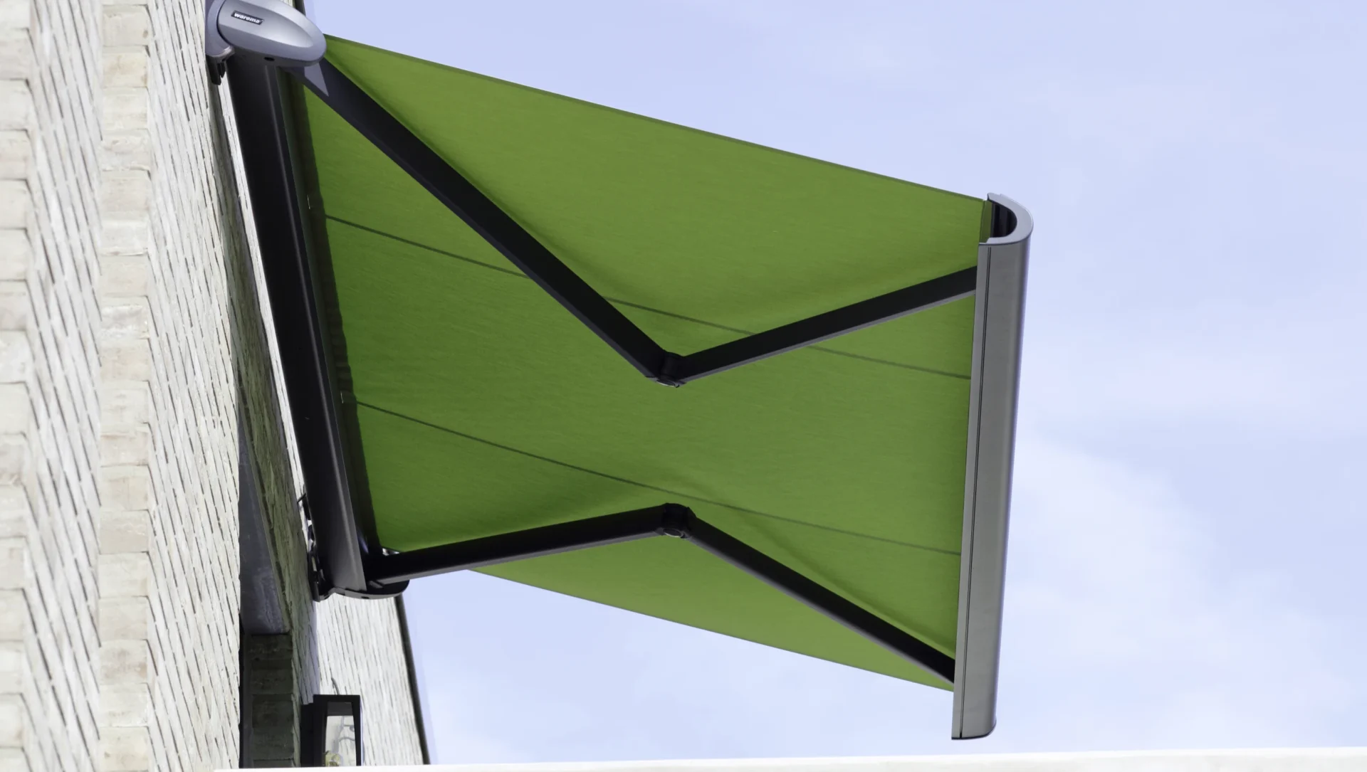 Grüne Markise an einer Backsteinwand