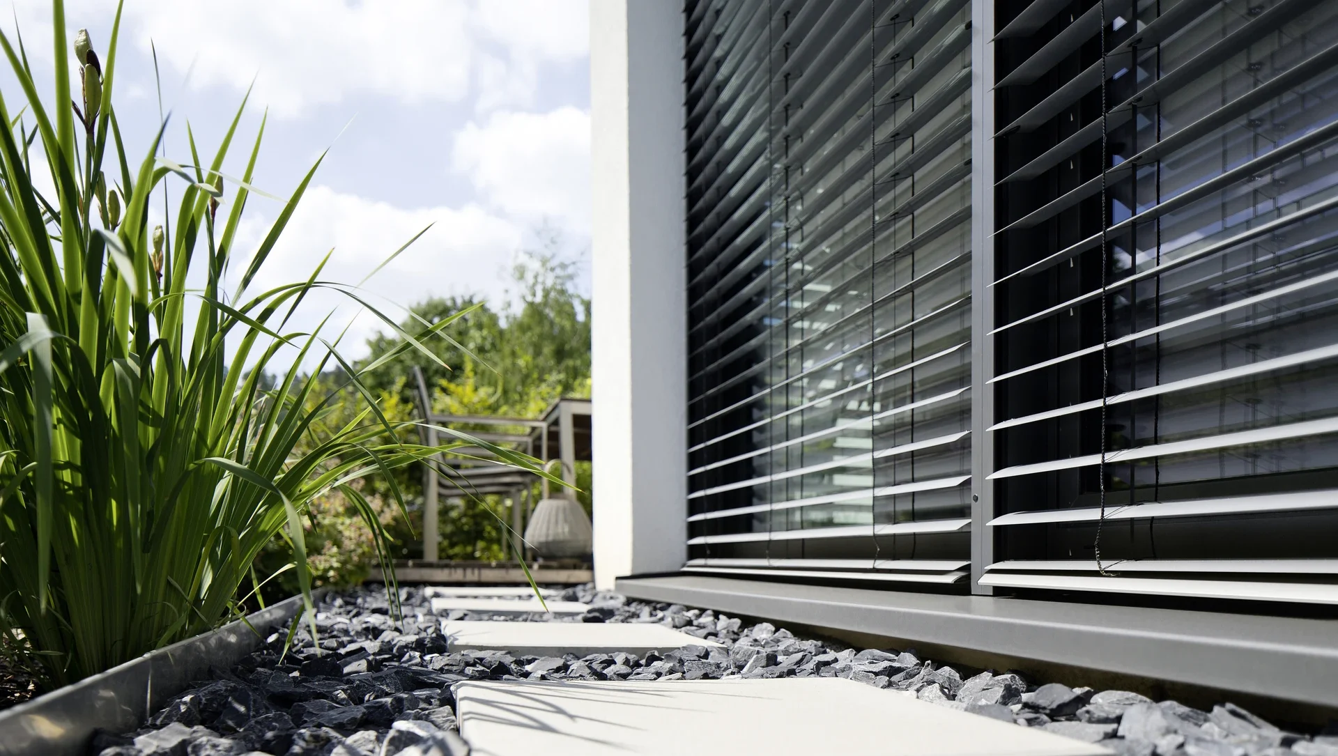 Moderne Jalousien an einem Haus mit Garten