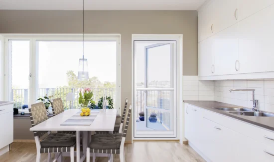 Moderne helle Küche mit Esstisch und großen Fenstern
